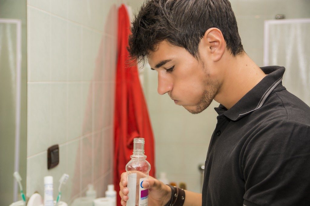 man using mouthwash