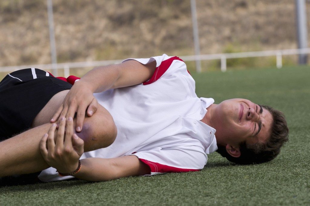 Football player experiencing pain in his knee