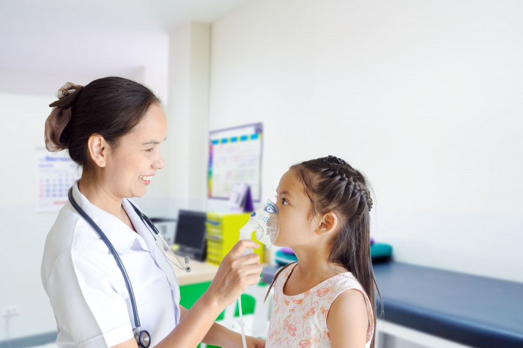 nurse holding a respirator over a child's face