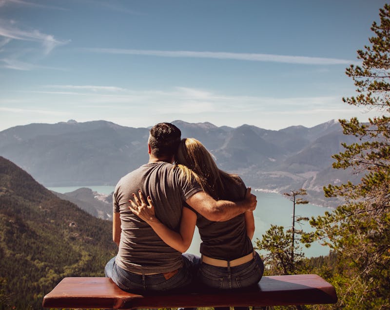 a couple in the mountains looking at the lake