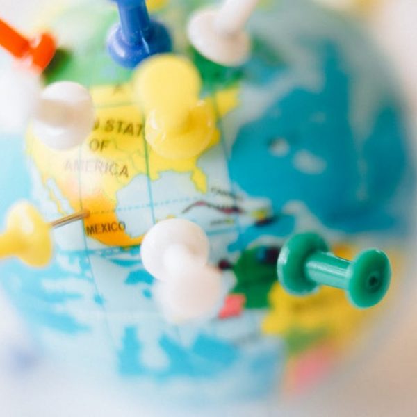 a small globe with push pins marking certain locations