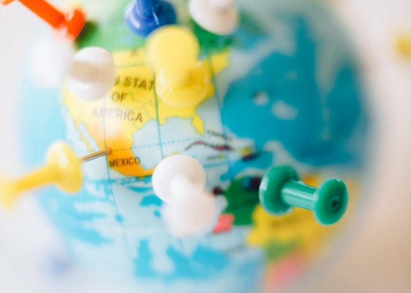 a small globe with push pins marking certain locations