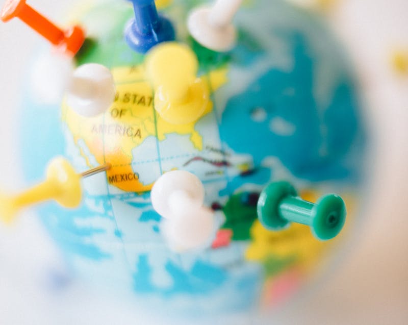 a small globe with push pins marking certain locations